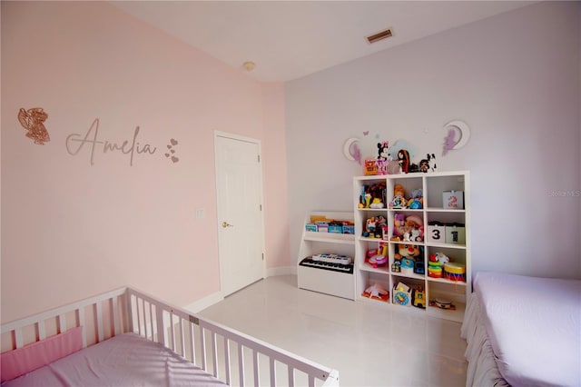 tiled bedroom with visible vents, a crib, and baseboards