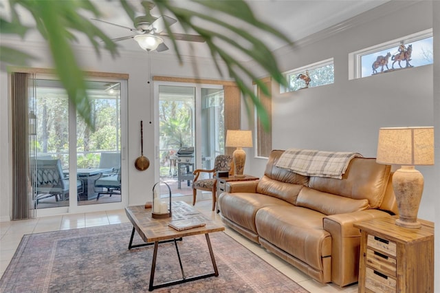 living area with tile patterned flooring, crown molding, and ceiling fan