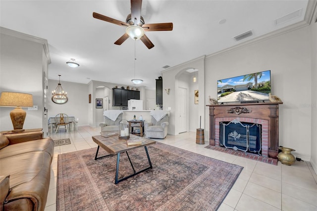 living room with a brick fireplace, light tile patterned floors, arched walkways, and visible vents