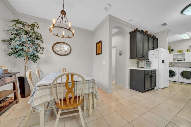 dining area featuring an inviting chandelier, washing machine and dryer, visible vents, and arched walkways