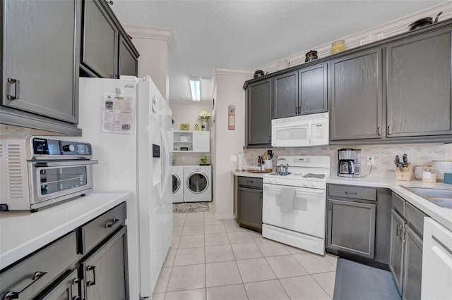 kitchen with tasteful backsplash, washer and dryer, white appliances, and light countertops