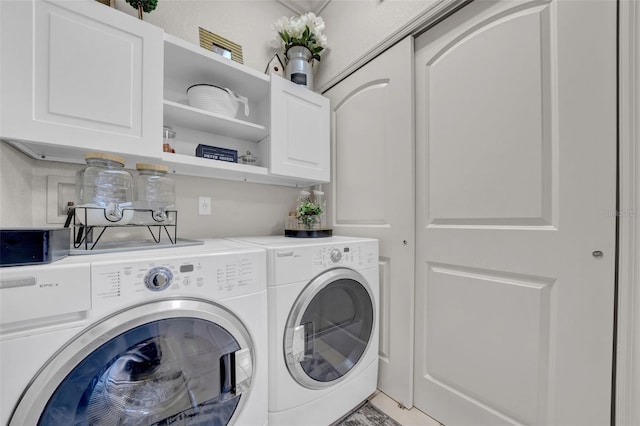 clothes washing area with cabinet space and washer and clothes dryer