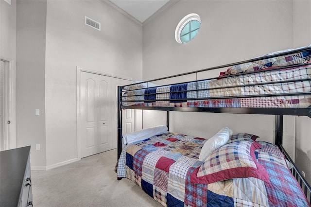 bedroom featuring visible vents, crown molding, baseboards, carpet, and a high ceiling