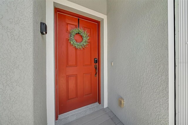 doorway to property featuring stucco siding