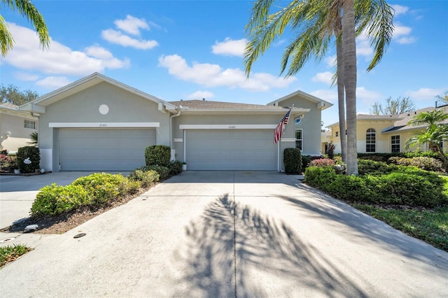 ranch-style home featuring stucco siding, driveway, and an attached garage