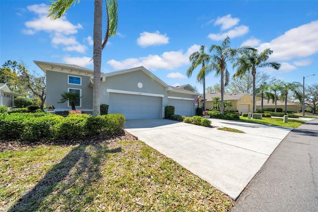 ranch-style home with a garage, concrete driveway, and stucco siding