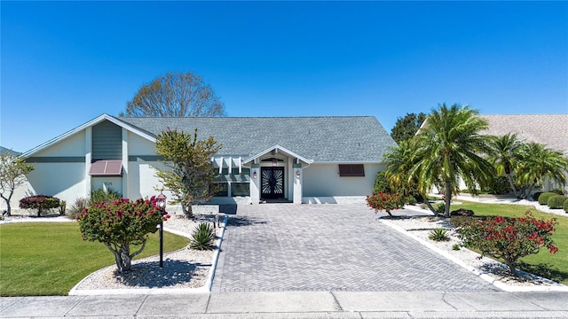 view of front of home featuring stucco siding and a front lawn