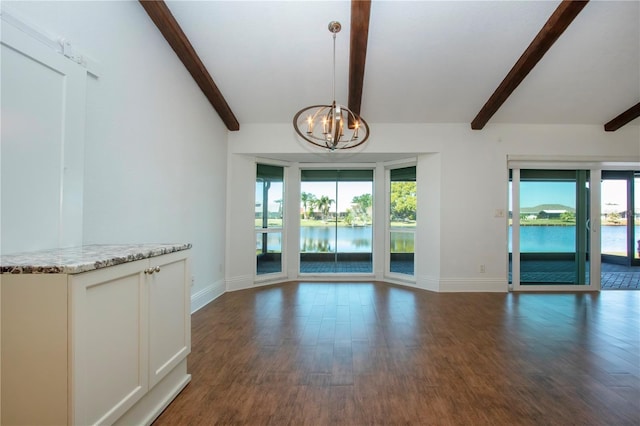 unfurnished living room featuring baseboards, a water view, a notable chandelier, and dark wood-style floors