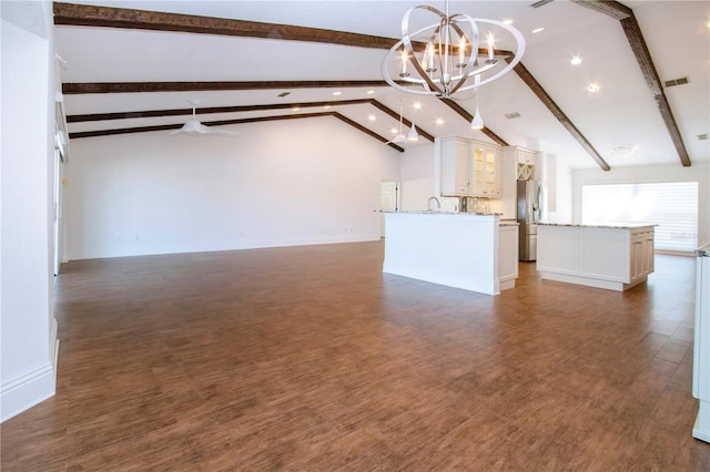 unfurnished living room featuring visible vents, baseboards, a chandelier, lofted ceiling with beams, and dark wood-style floors