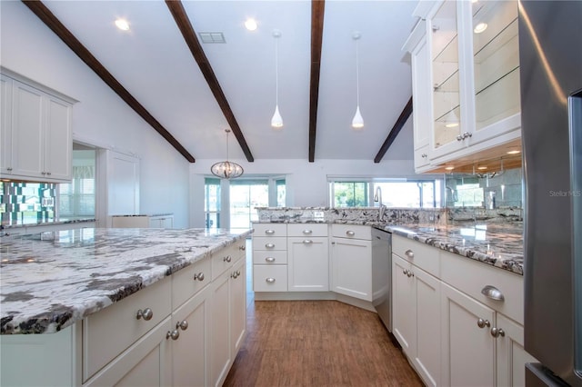 kitchen featuring lofted ceiling with beams, decorative backsplash, a peninsula, wood finished floors, and stainless steel appliances