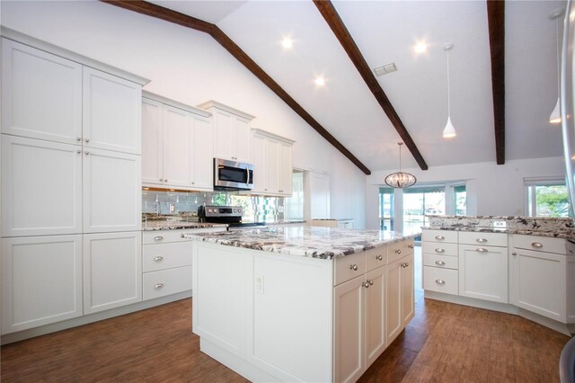 kitchen featuring visible vents, wood finished floors, a center island, appliances with stainless steel finishes, and decorative backsplash