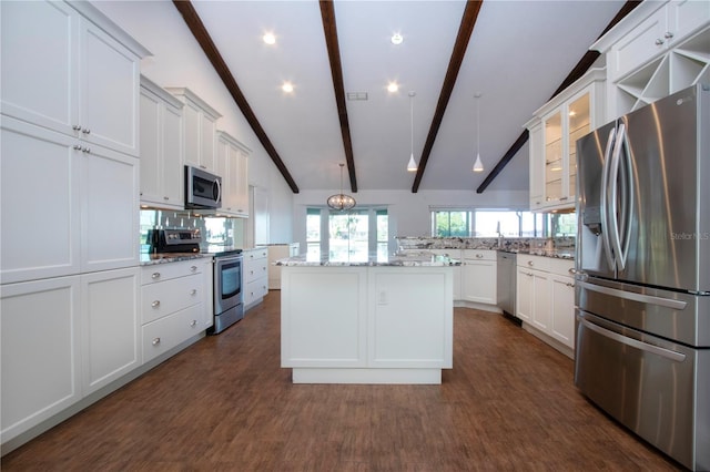 kitchen featuring a kitchen island, white cabinets, appliances with stainless steel finishes, and vaulted ceiling with beams