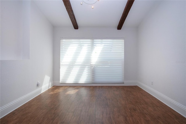 unfurnished room featuring beamed ceiling, baseboards, and wood finished floors