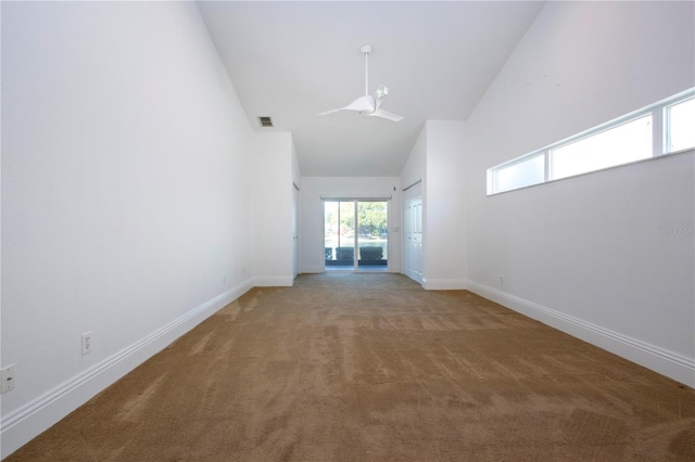 carpeted spare room featuring visible vents, baseboards, and high vaulted ceiling