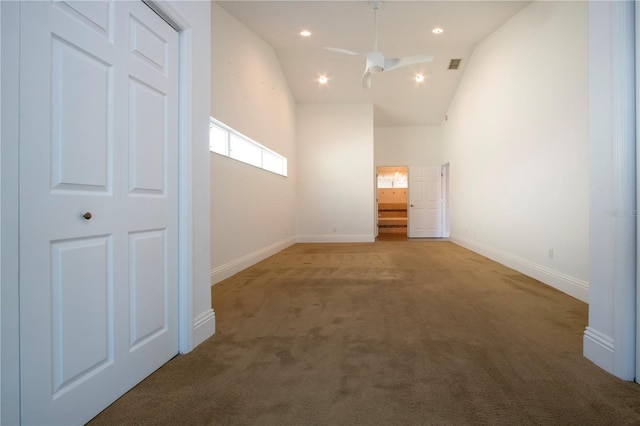 interior space with a ceiling fan, baseboards, carpet floors, high vaulted ceiling, and recessed lighting