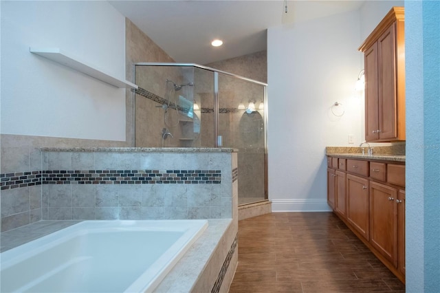 full bath featuring vanity, a garden tub, and a stall shower