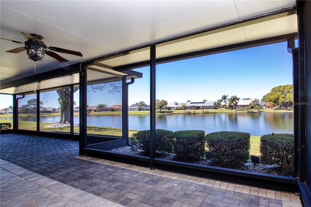 unfurnished sunroom with a water view, a healthy amount of sunlight, and a ceiling fan