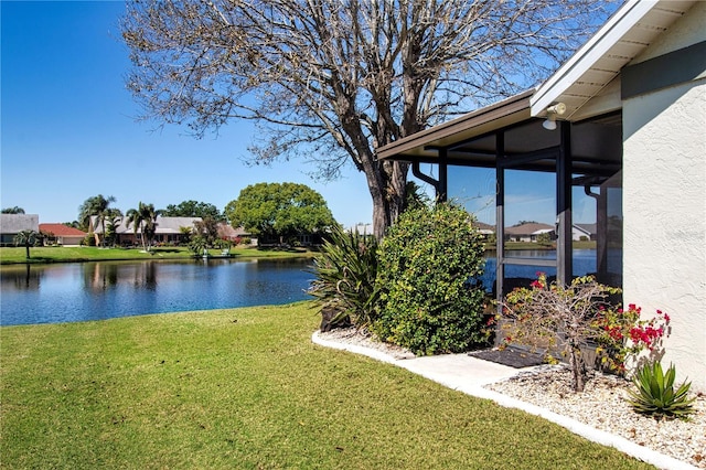 view of yard featuring a water view and a sunroom