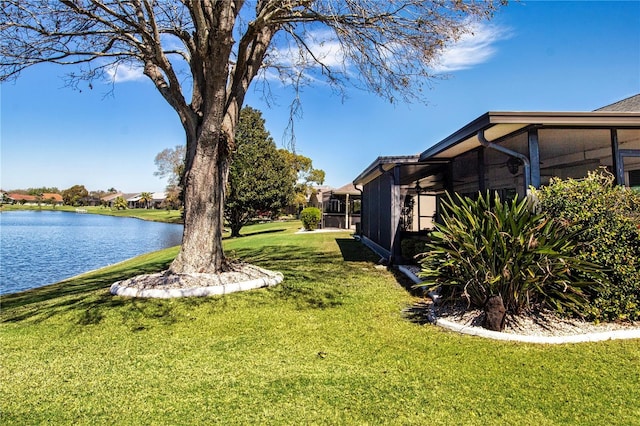 view of yard featuring a water view and a sunroom