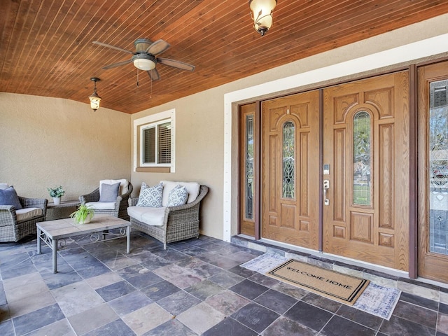 view of exterior entry featuring stucco siding and ceiling fan