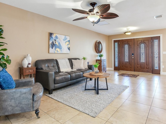 living room with light tile patterned floors, visible vents, and baseboards