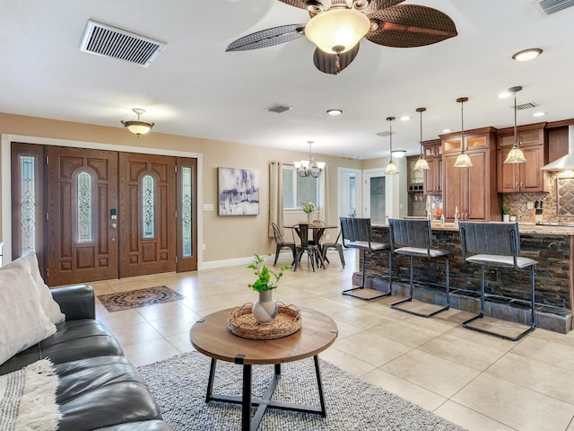 living area with light tile patterned floors, visible vents, and baseboards