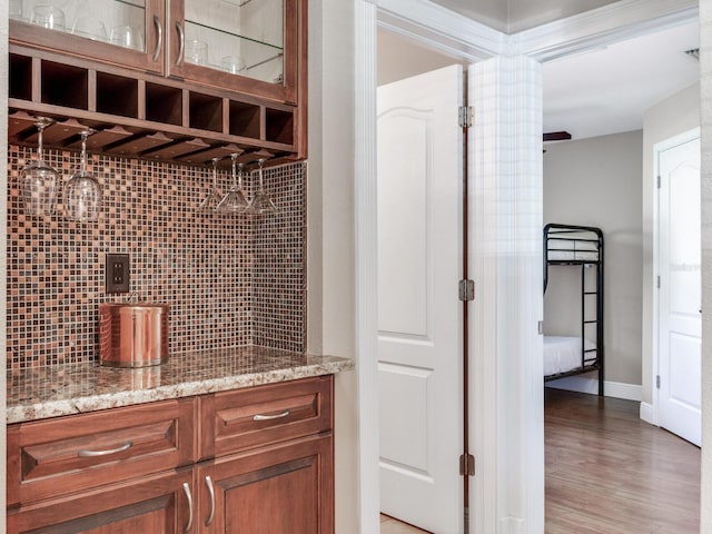 bar featuring tasteful backsplash, baseboards, and light wood-style floors