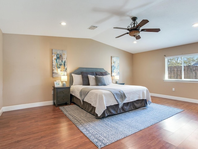 bedroom featuring vaulted ceiling, visible vents, baseboards, and wood finished floors