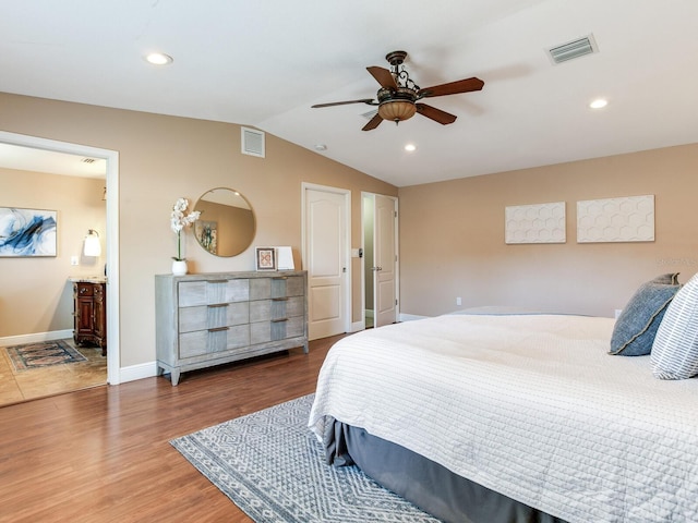 bedroom with vaulted ceiling, recessed lighting, wood finished floors, and visible vents