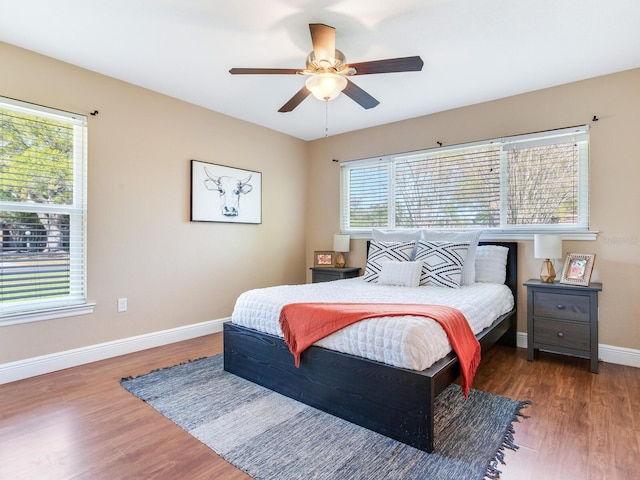 bedroom with baseboards, wood finished floors, and a ceiling fan