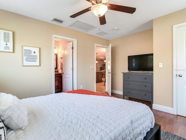 bedroom featuring attic access, wood finished floors, visible vents, and baseboards