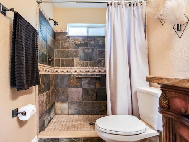 full bath featuring toilet and a tile shower