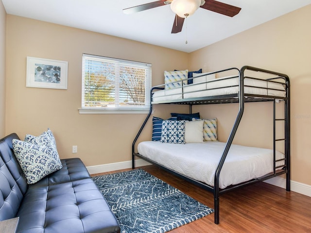 bedroom with ceiling fan, baseboards, and wood finished floors