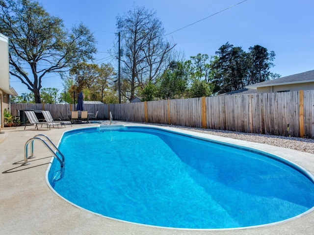 view of swimming pool with a fenced backyard, a fenced in pool, and a patio