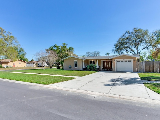 single story home with stucco siding, driveway, a front lawn, fence, and an attached garage