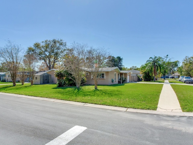 single story home with stucco siding, a residential view, and a front lawn