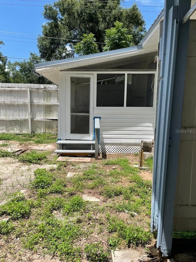 doorway to property featuring fence
