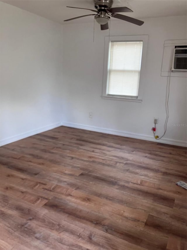 unfurnished room featuring baseboards, wood finished floors, a wall unit AC, and ceiling fan