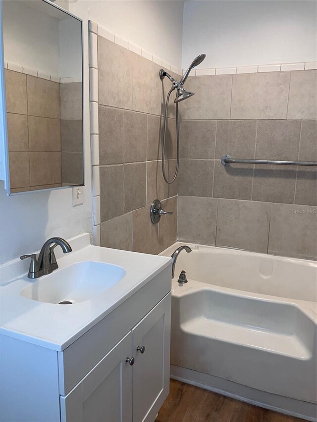 bathroom featuring shower / bathing tub combination, wood finished floors, and vanity