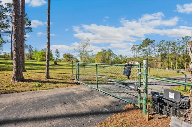 view of gate with a lawn and fence