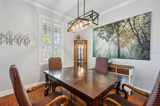 dining area with baseboards, wood finished floors, and crown molding