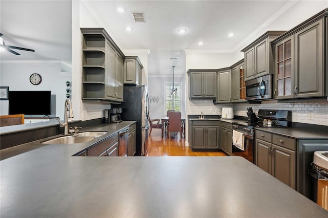 kitchen featuring open shelves, dark countertops, appliances with stainless steel finishes, and a sink