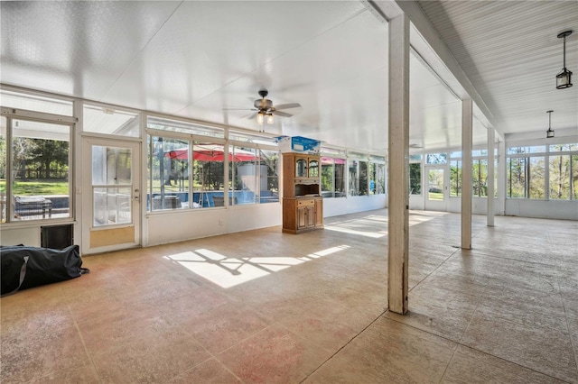 unfurnished sunroom featuring ceiling fan