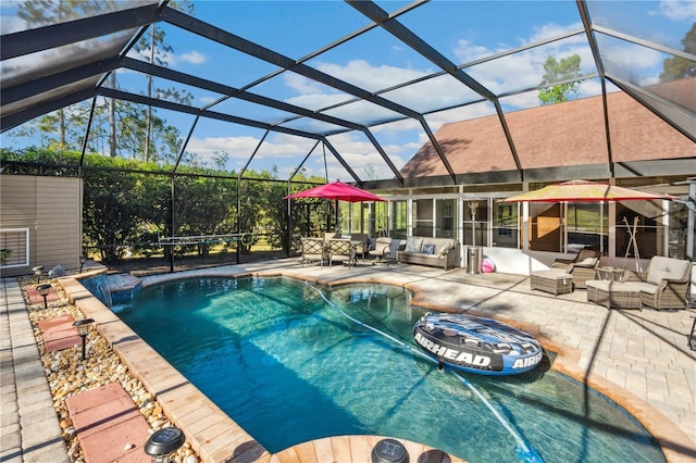 pool featuring glass enclosure, outdoor lounge area, and a patio