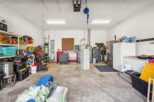 garage featuring stainless steel fridge with ice dispenser, gas water heater, electric panel, a workshop area, and a garage door opener