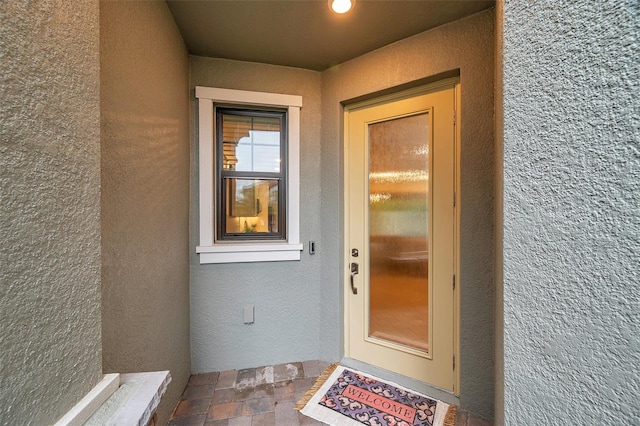 entrance to property featuring stucco siding