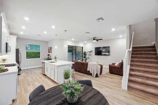 dining room with stairs, recessed lighting, baseboards, and light wood finished floors