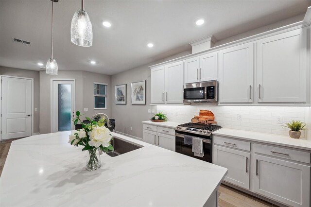 kitchen with visible vents, recessed lighting, stainless steel appliances, decorative light fixtures, and tasteful backsplash