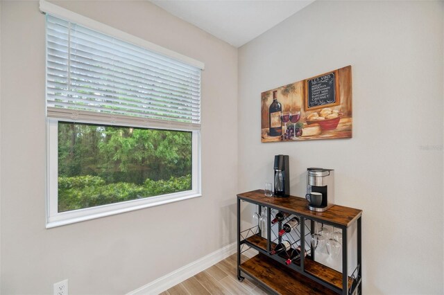 corridor featuring baseboards and wood finished floors