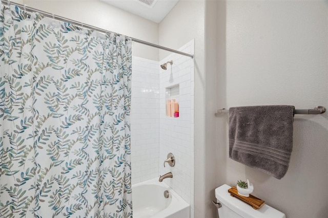 bathroom with shower / bath combo with shower curtain and toilet